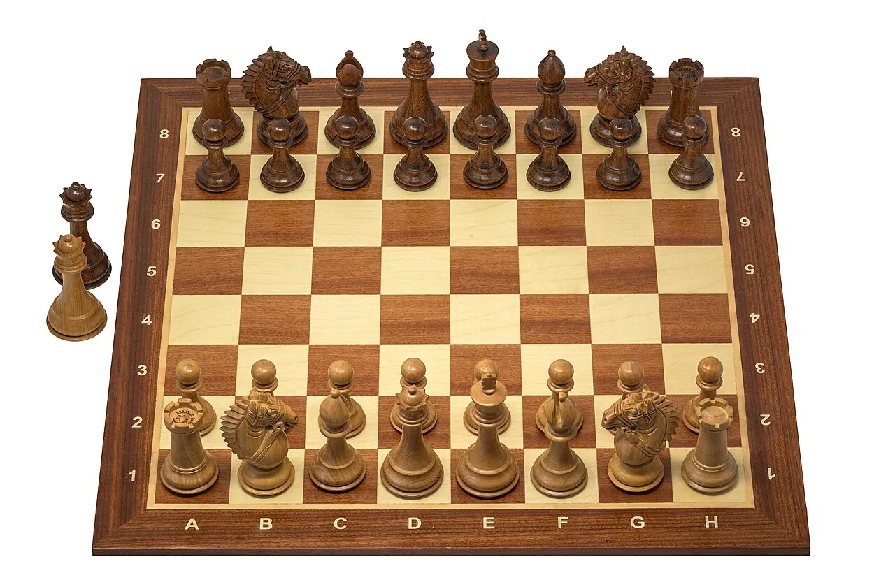 Chess pieces arranged on a wooden chessboard