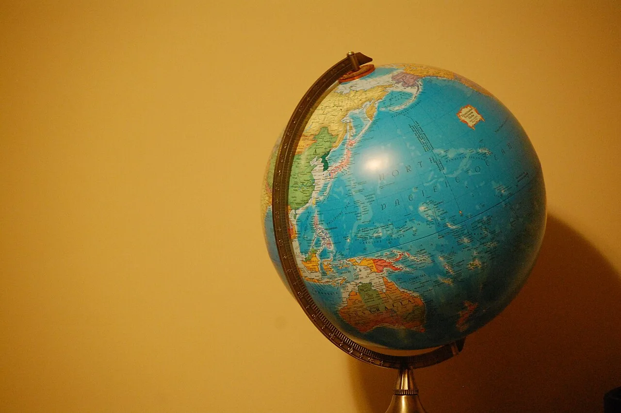 A tabletop globe against a warm yellow background