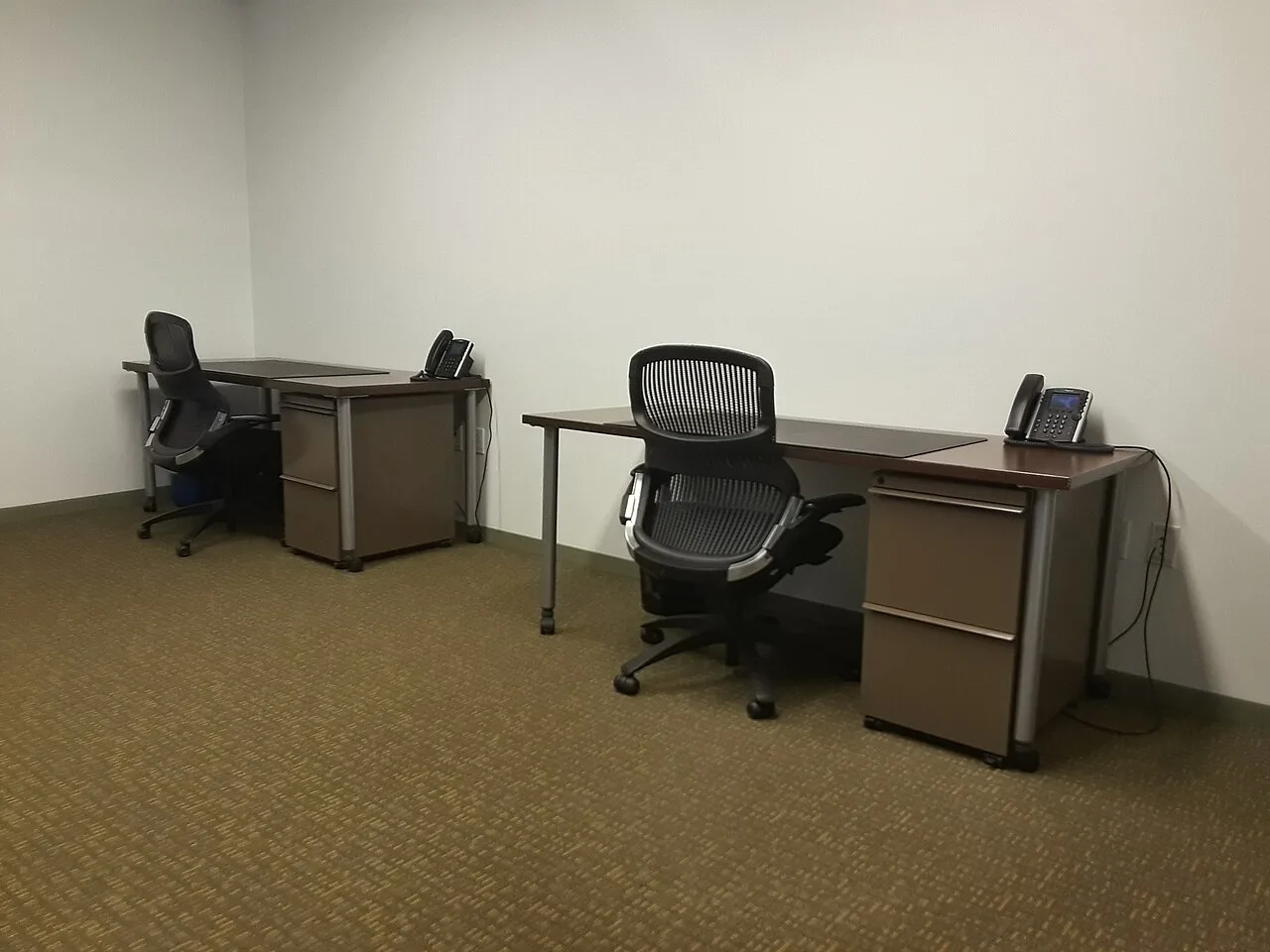 Two desks and office chairs in a shared workspace