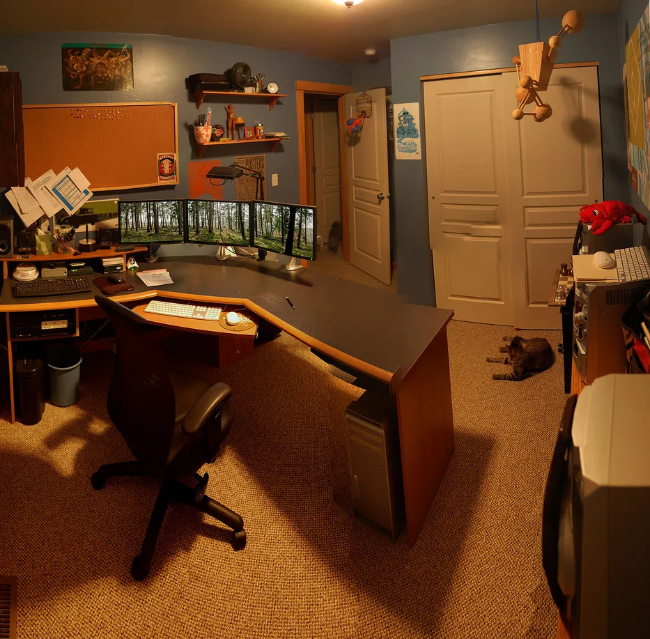 A home workspace with a desk, chair, books, and everyday objects