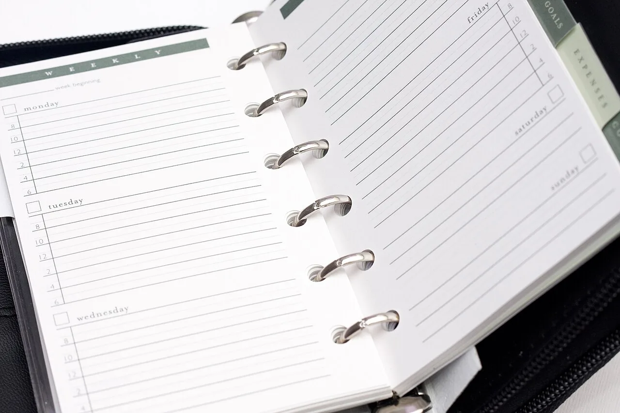 An open ring-bound planner with blank ruled pages