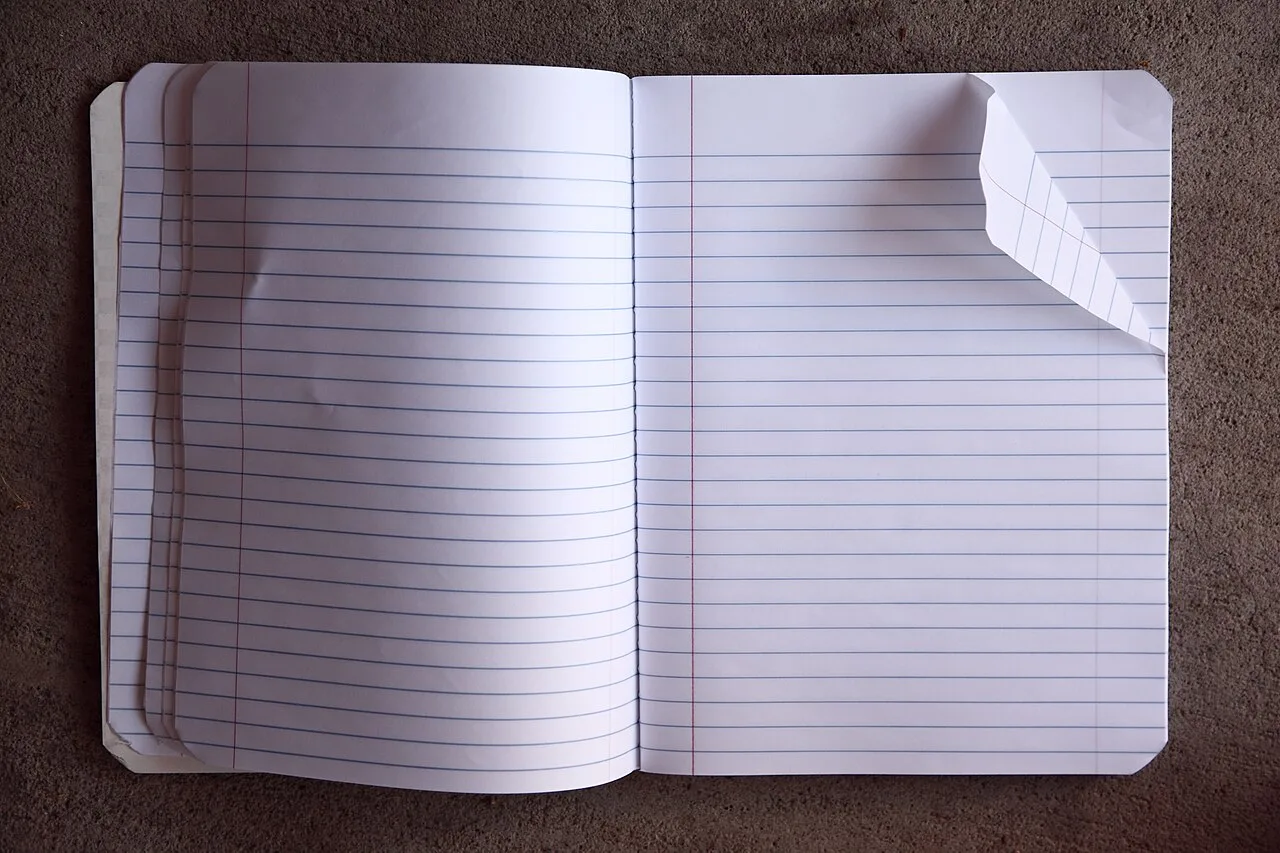 A blank lined notebook opened on a table