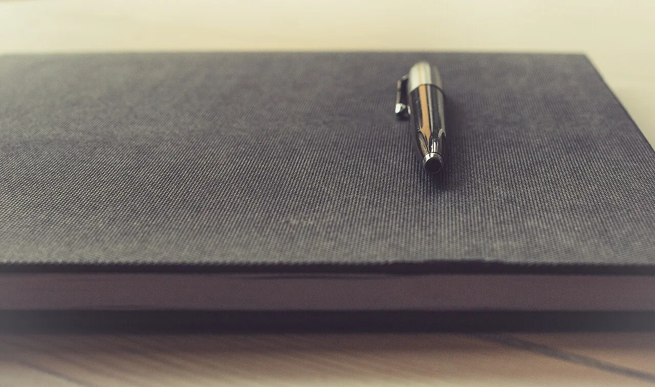 A pen resting on a closed notebook