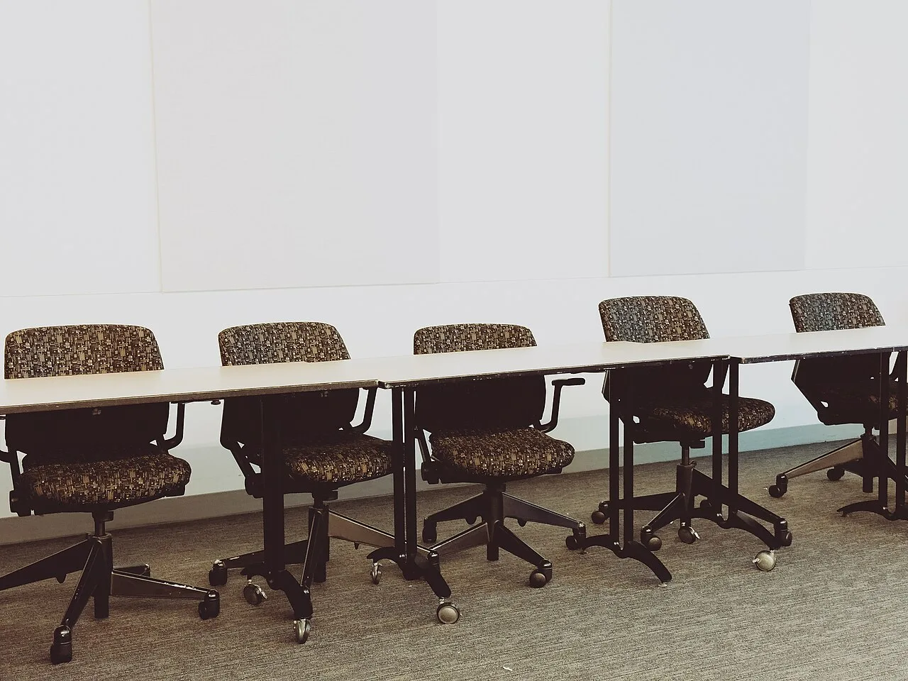 Office chairs arranged along a long meeting table