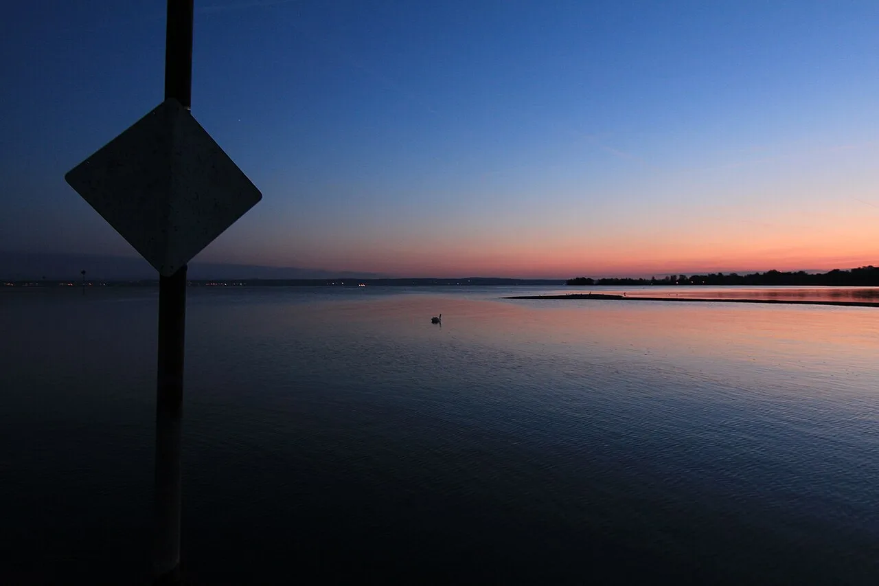 Still water and the colors of dusk along a quiet shore