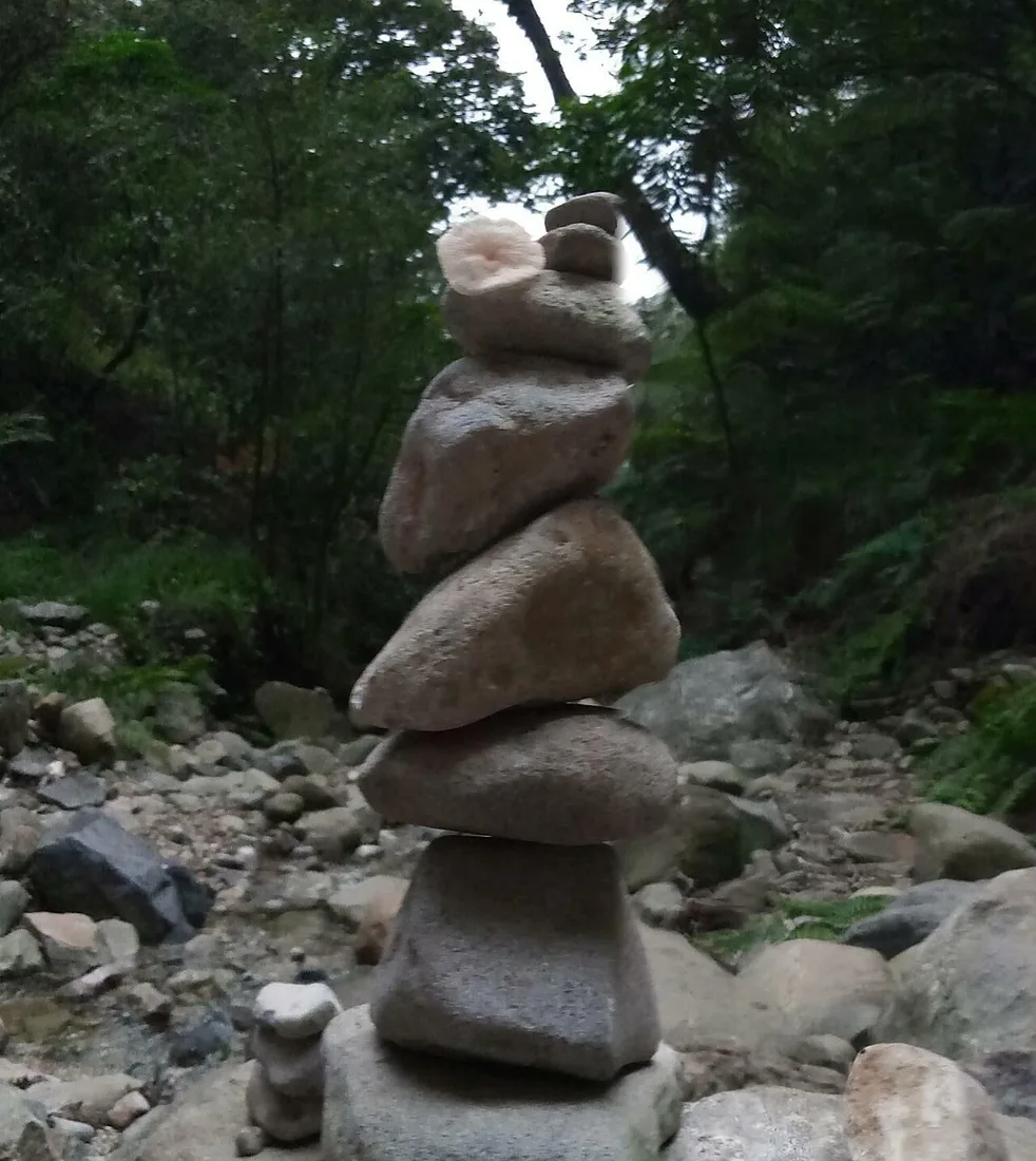 Stones carefully balanced in a tall stack beside a stream