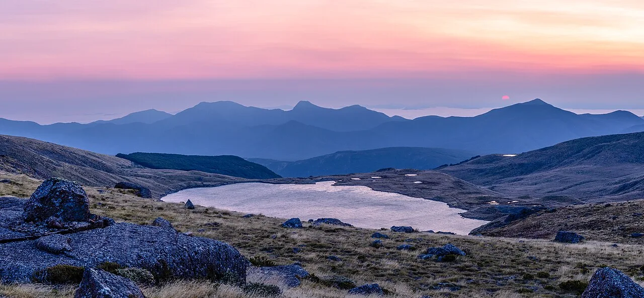 A mountain lake beneath a pastel sunrise